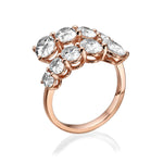 Rose gold ring with pear-shaped diamonds on a white background