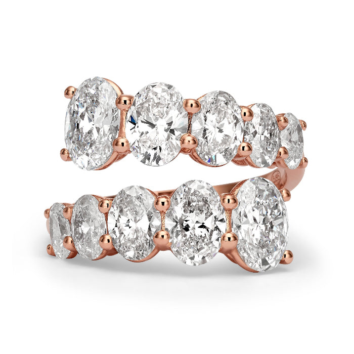 Gold ring with oval-shaped diamonds on a white background